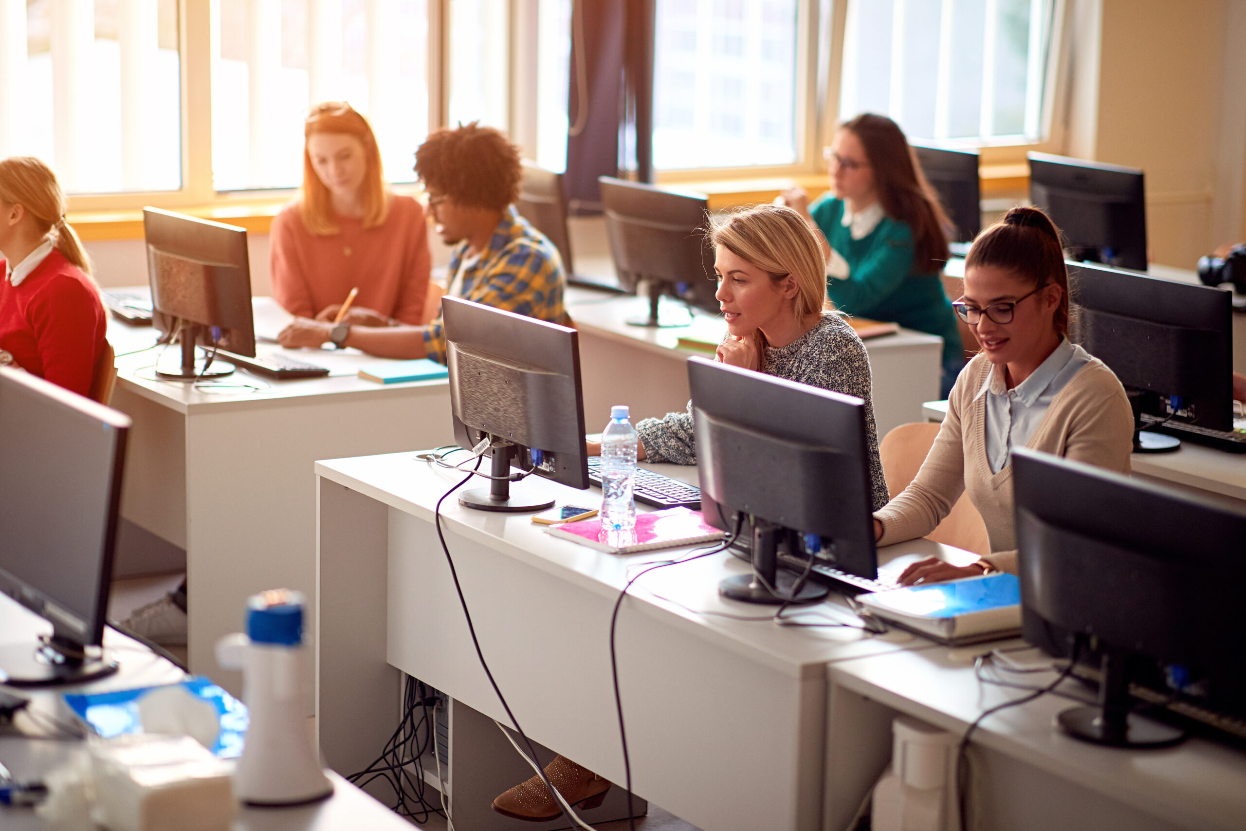 IT workshop at university. Group of Students on class with compu