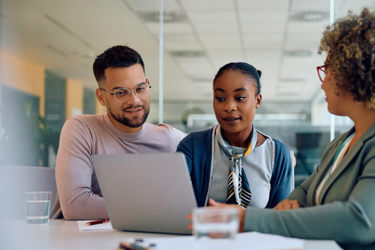 Young couple and their financial advisor using laptop during meeting in office.